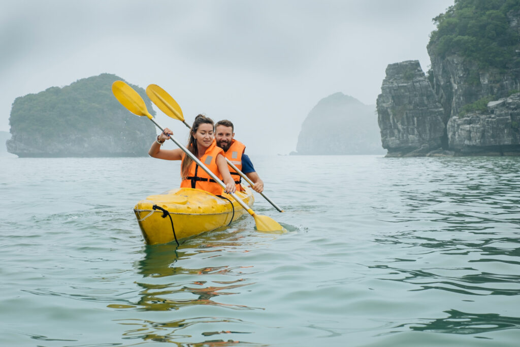 Couple rowing using kayak at covered fog with mist